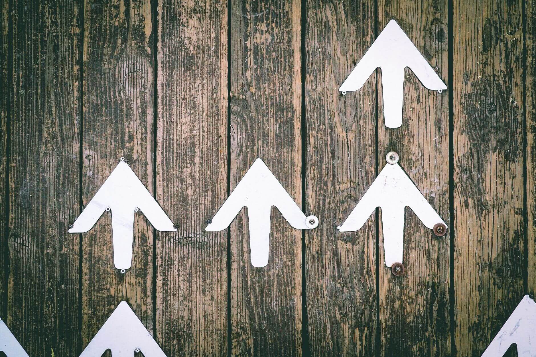 Hanging arrows facing upwards on wooden wall