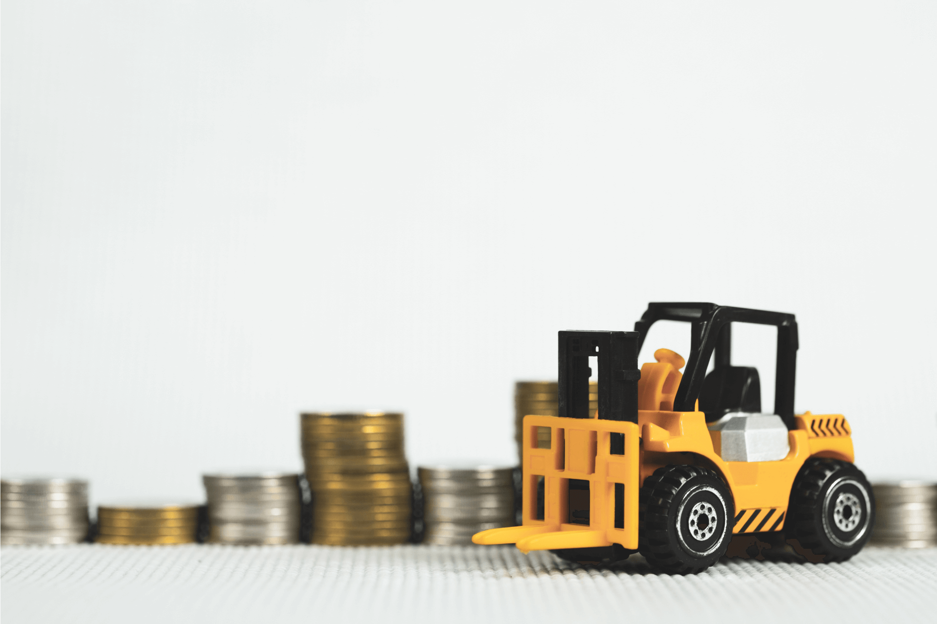 Toy forklift in front of stacks of coins