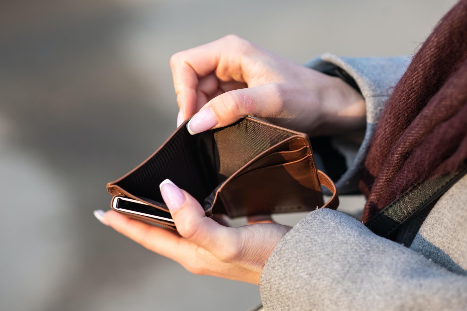 A woman holding open an empty wallet